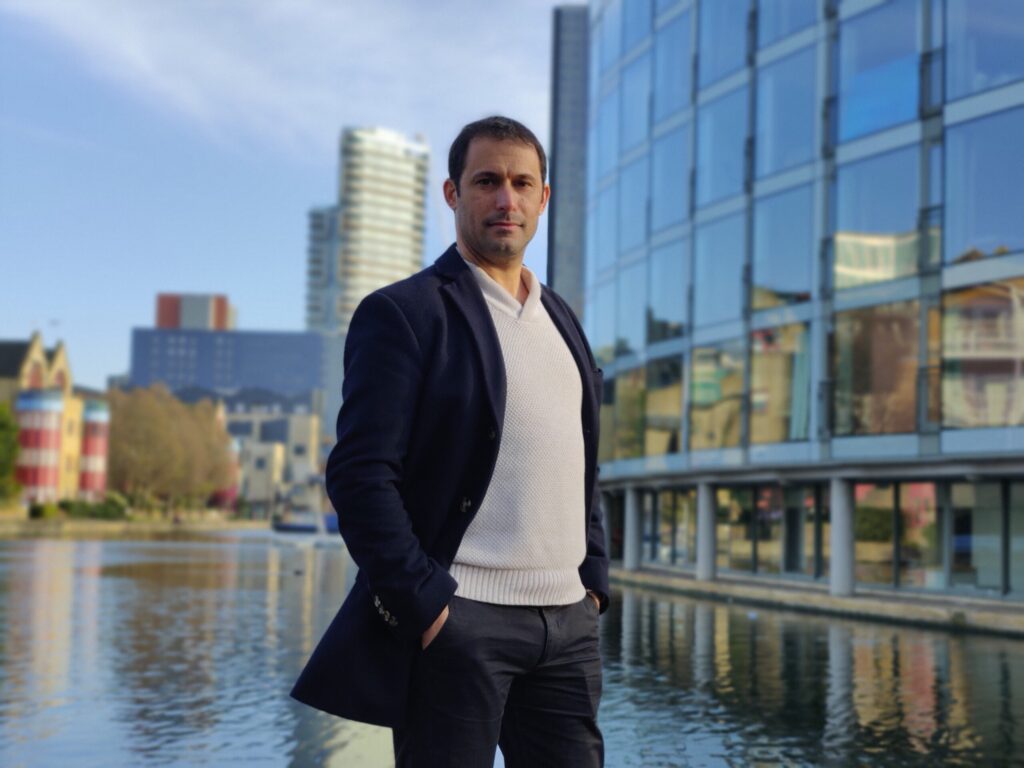 Person against the backdrop of a river and a glass building